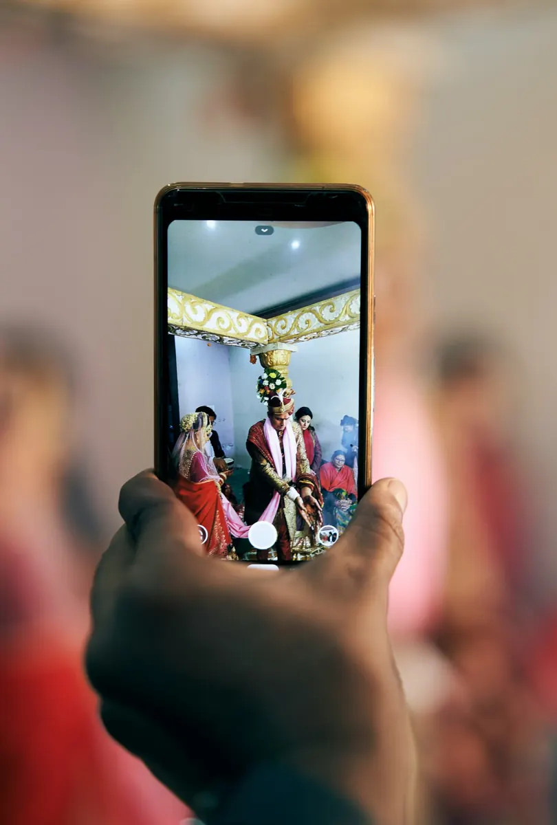 A wedding ceremony seen through a guest's phone screen