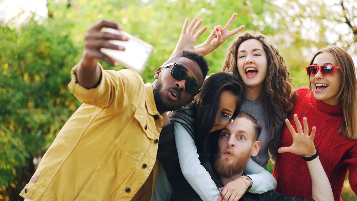 A group of friends taking a playful selfie outdoors
